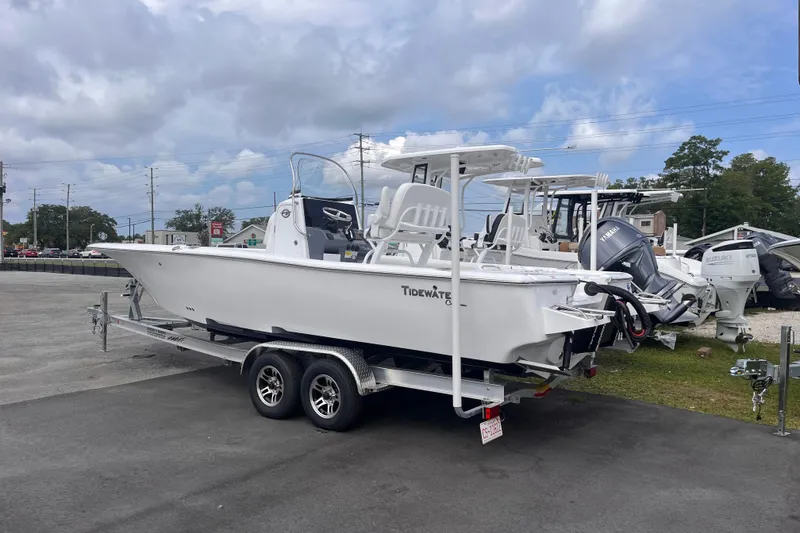 Slide: The Image of 2027 Tidewater 2500 Carolina Bay boat on trailer, parked outdoors under cloudy sky. - 2