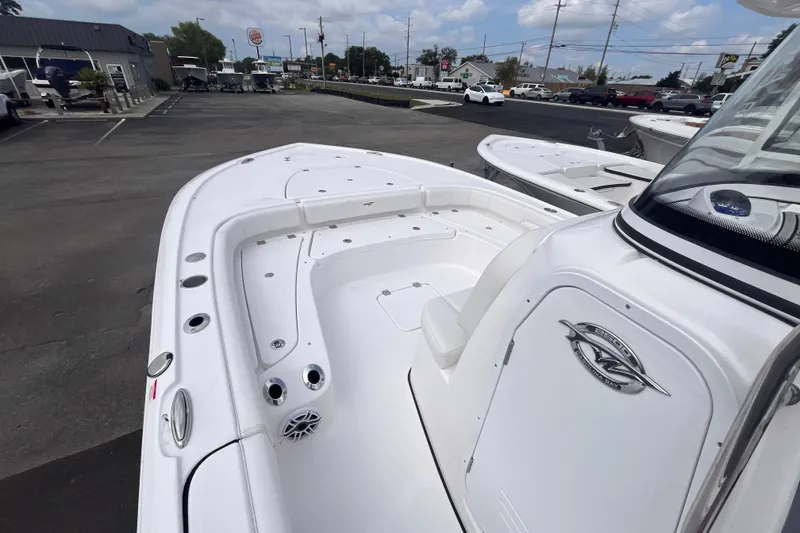 Slide: The Image of 2027 Tidewater 2500 Carolina Bay boat, sleek white design, parked in dealership lot. - 7