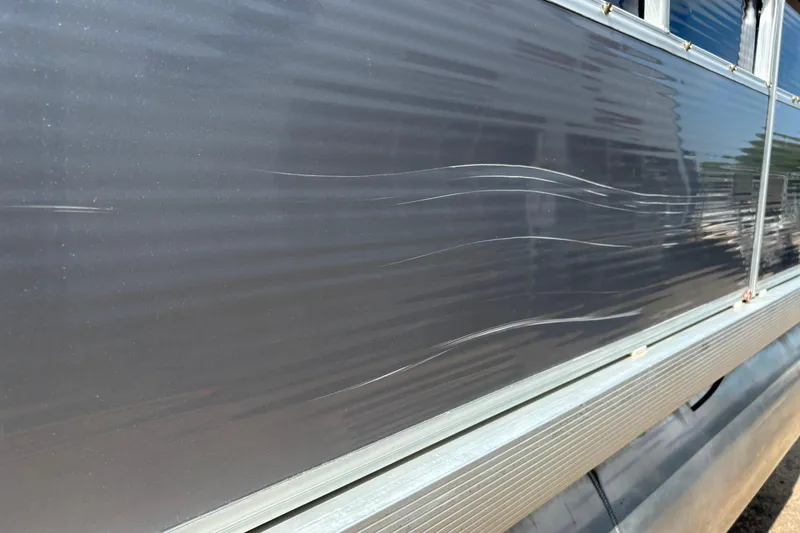 Slide: The Image of Scratched exterior of a 2006 South Bay 23 boat, showing surface damage. - 9