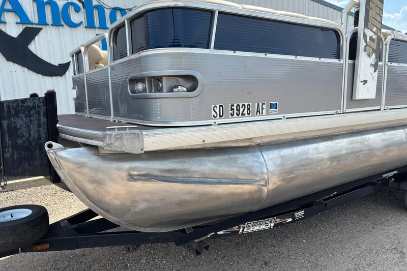 Slide: The Image of 2006 South Bay 23 pontoon boat on trailer, parked outside a building. - 8
