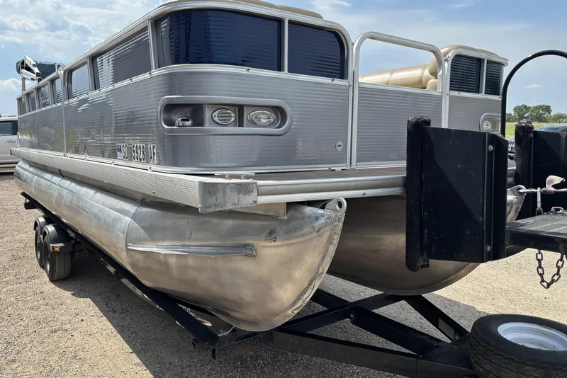 Slide: The Image of 2006 South Bay 23 pontoon boat on trailer, silver exterior, parked outdoors. - 1