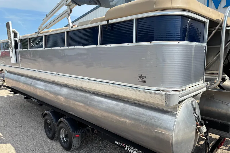 Slide: The Image of 2006 South Bay 23 pontoon boat on trailer, silver and blue exterior, parked outdoors. - 7