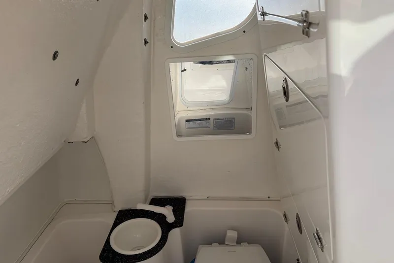 Slide: The Image of Interior of 2022 Sea Fox 268 Commander boat, featuring compact bathroom with sink and toilet. - 16