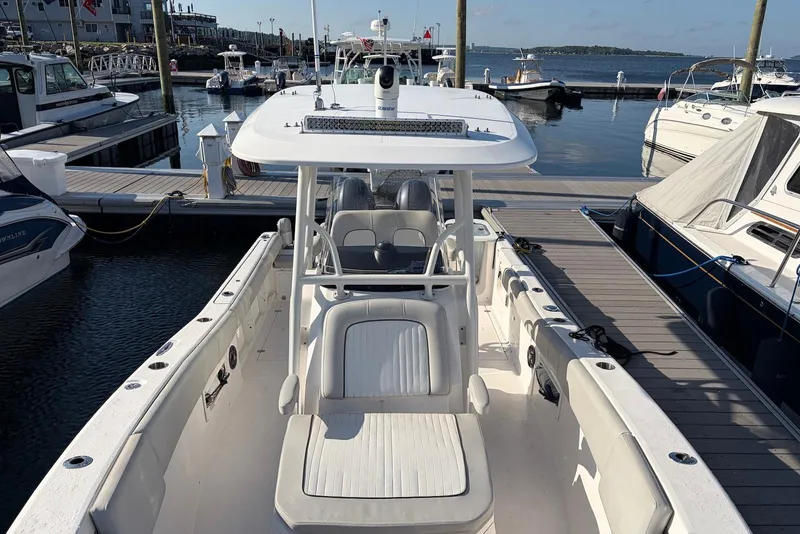 Slide: The Image of 2022 Sea Fox 268 Commander boat docked at a marina, showcasing spacious deck and seating. - 10