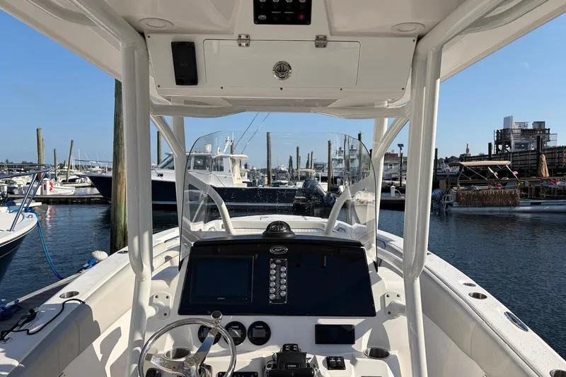 Slide: The Image of 2022 Sea Fox 268 Commander boat dashboard at marina, showcasing navigation controls and steering wheel. - 15