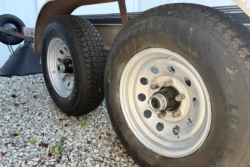 Slide: The Image of Trailer wheels on gravel, part of a 2022 Sea Fox 268 Commander boat trailer. - 21