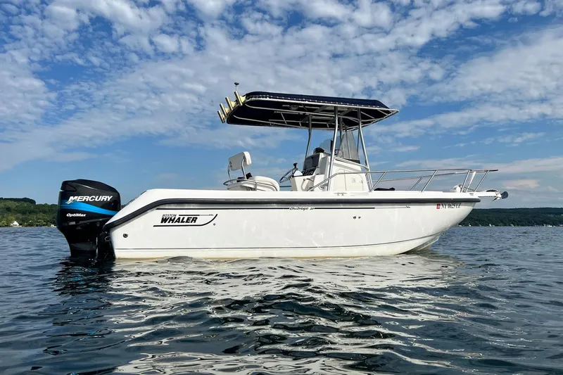 Slide: The Image of 2001 Boston Whaler 210 Outrage boat on water, featuring Mercury OptiMax engine. - 4