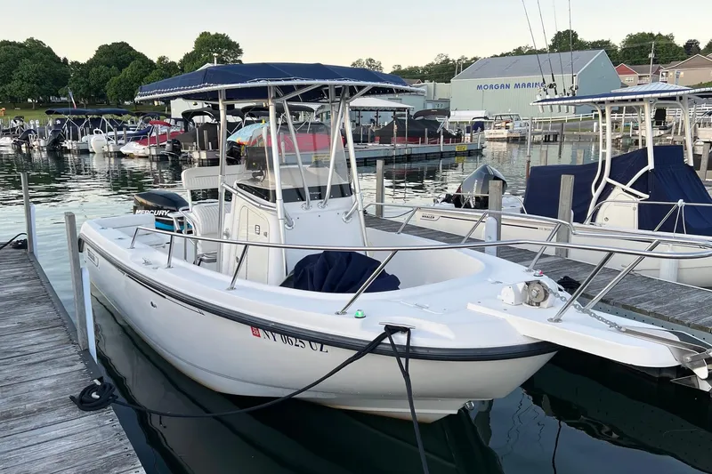 Slide: The Image of 2001 Boston Whaler 210 Outrage docked at marina with other boats in background. - 3