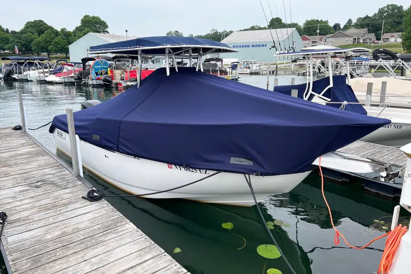 Slide: The Image of Boston Whaler 210 Outrage 2001 boat docked with blue cover at marina. - 5