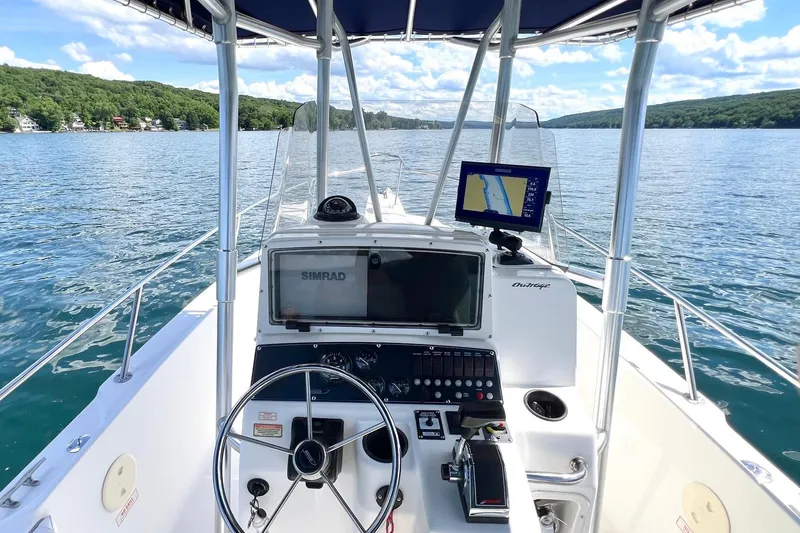 Slide: The Image of Boston Whaler 210 Outrage 2001 boat dashboard with navigation system on a scenic lake. - 2