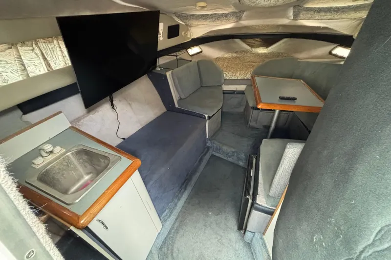 Slide: The Image of Interior of 1992 Bayliner 2850 Contessa boat with seating, table, sink, and TV. - 7