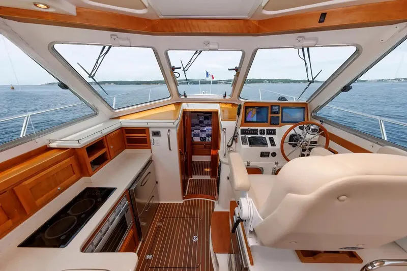Slide: The Image of 2017 Back Cove Yachts 37 interior with helm, navigation equipment, and wooden cabinetry. - 40