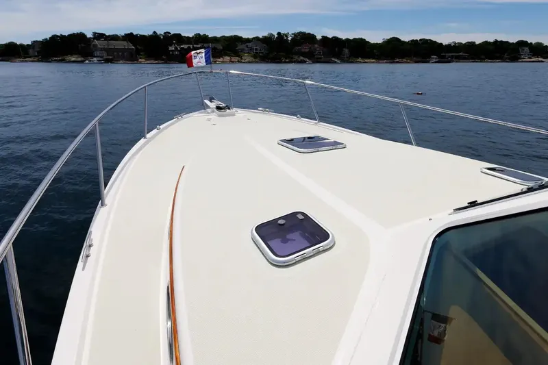Slide: The Image of 2017 Back Cove Yachts 37 on calm water, showcasing sleek deck design and scenic shoreline. - 21