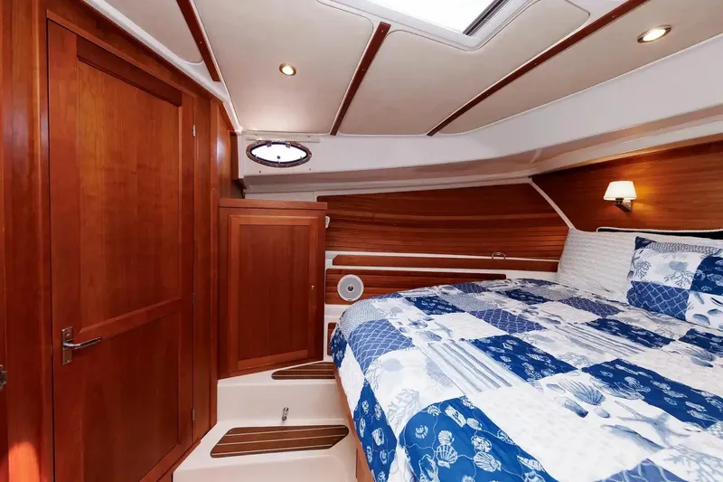 Slide: The Image of Luxurious cabin interior of 2017 Back Cove Yachts 37 with wood paneling and cozy bedding. - 48