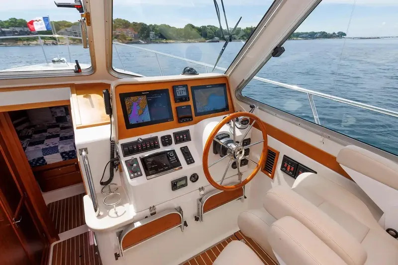 Slide: The Image of Helm of 2017 Back Cove Yachts 37, featuring navigation equipment and wooden steering wheel. - 35