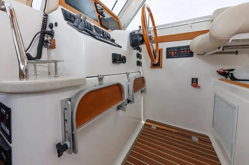 Slide: The Image of Interior helm of 2017 Back Cove Yachts 37 with wooden steering wheel and control panels. - 38