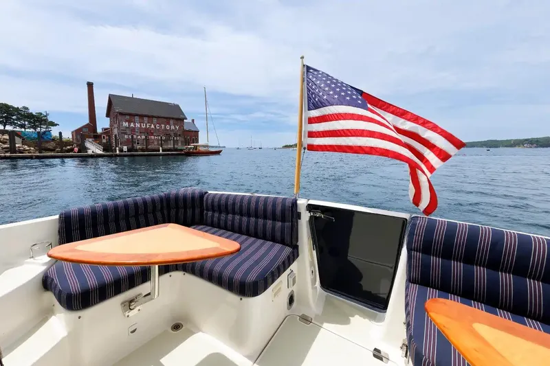 Slide: The Image of Back Cove Yachts 37 (2017) with American flag, docked near historic waterfront building. - 28