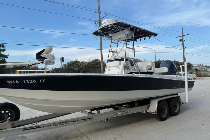 Slide: The Image of 2008 Triton 240 LTS boat on trailer, featuring a T-top and outboard motor. - 7