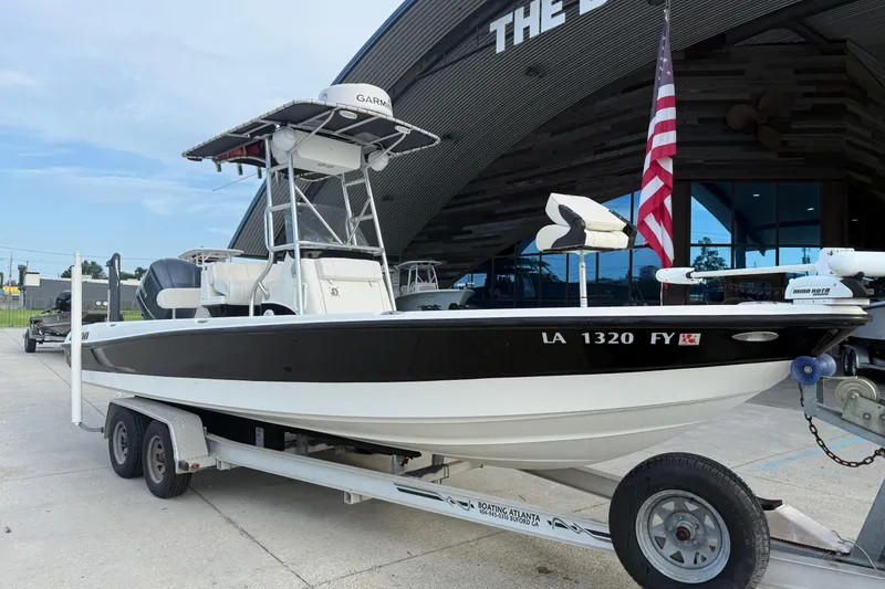 Slide: The Image of 2008 Triton 240 LTS boat on trailer, parked outside a building with an American flag. - 3