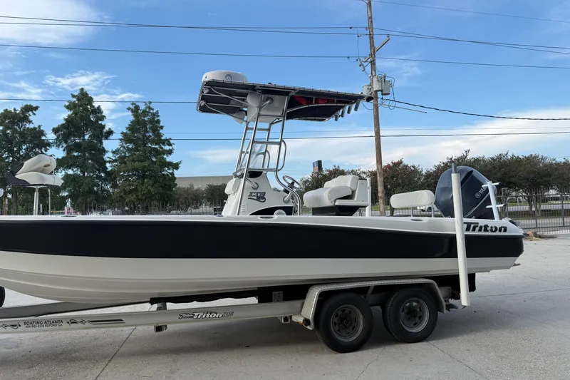 Slide: The Image of 2008 Triton 240 LTS boat on trailer, parked outdoors under clear sky. - 8
