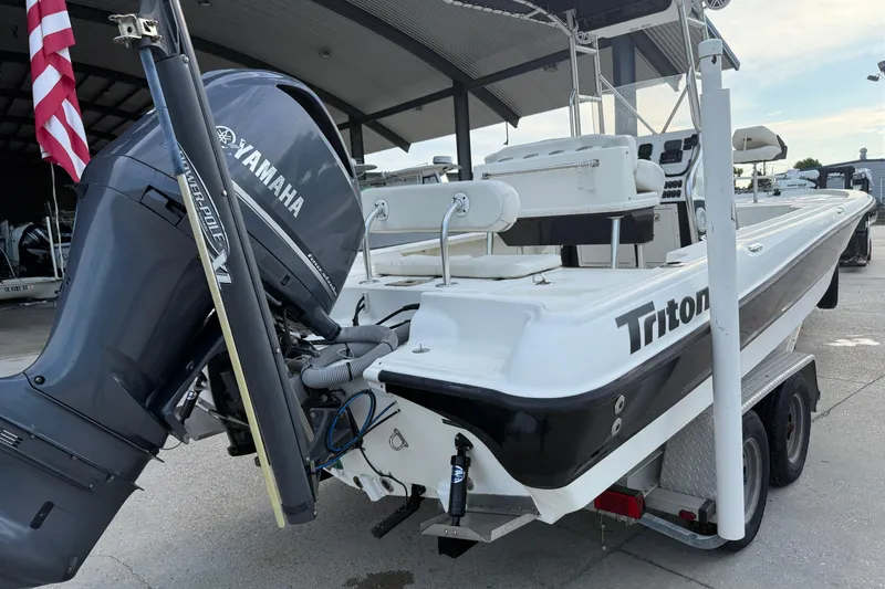 Slide: The Image of 2008 Triton 240 LTS boat with Yamaha outboard motor, parked on a trailer. - 12