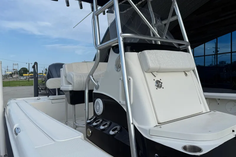 Slide: The Image of 2008 Triton 240 LTS boat interior with seating and console, docked outdoors. - 16