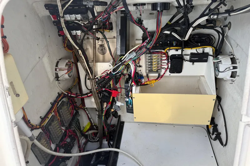 Slide: The Image of 2008 Triton 240 LTS boat wiring compartment with organized cables and electrical components. - 18