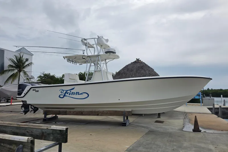 Slide: The Image of 2016 SeaVee 320B boat on dock, featuring sleek design and outboard motor. - 15