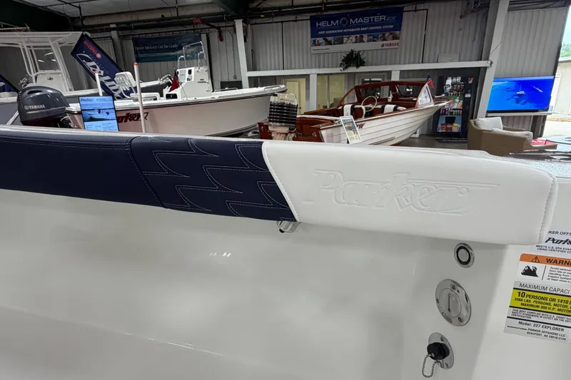 Slide: The Image of 2027 Parker 227 Explorer boat interior at a showroom, featuring branded seating and Yamaha engine. - 9