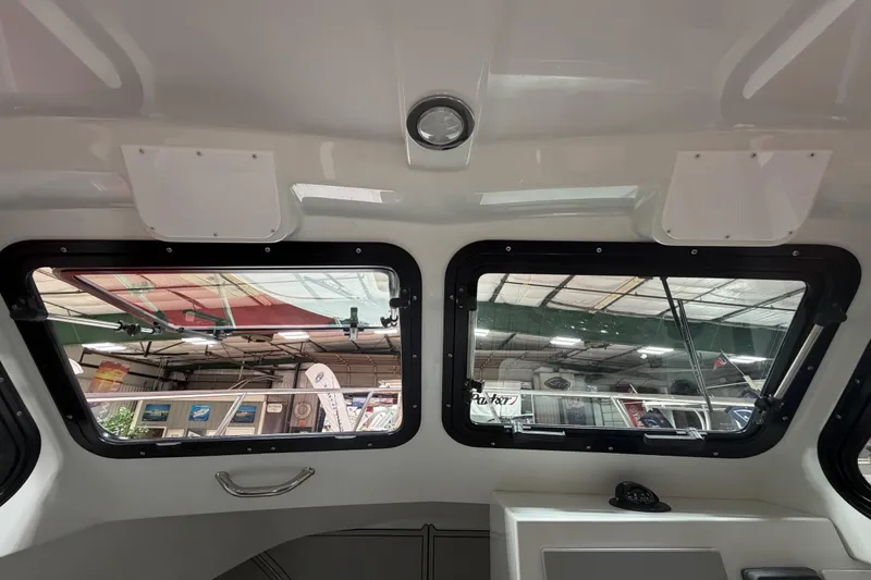 Slide: The Image of Interior view of 2027 Parker 227 Explorer boat windows at a showroom. - 13