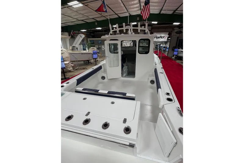 Slide: The Image of 2027 Parker 227 Explorer boat interior at a showroom, featuring spacious deck and seating. - 7