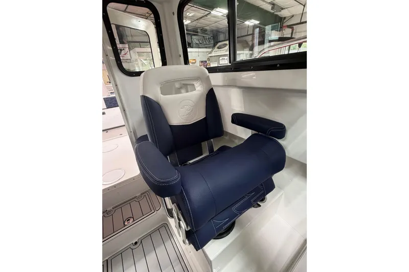 Slide: The Image of Captain's chair in 2027 Parker 227 Explorer boat, featuring blue and white upholstery. - 15