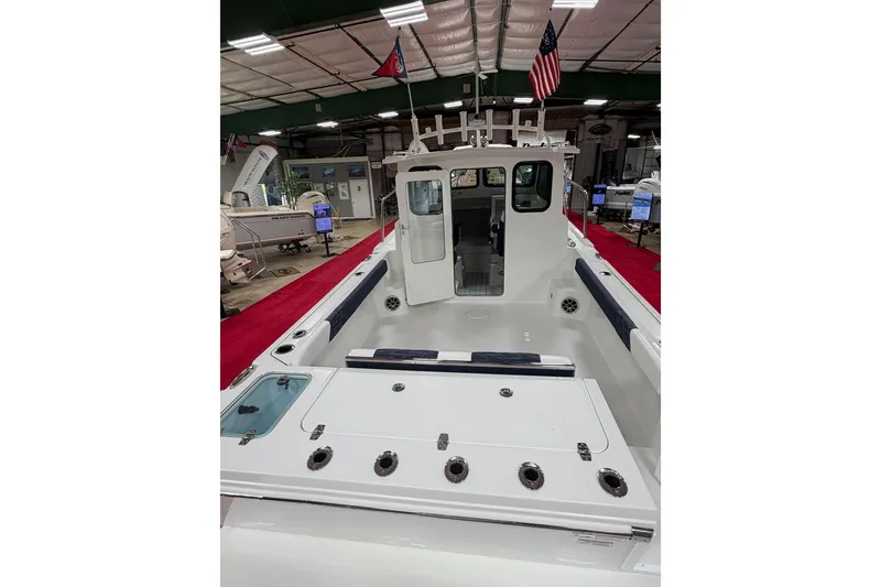 Slide: The Image of 2027 Parker 227 Explorer boat interior at a showroom, featuring spacious deck and seating. - 6