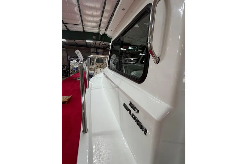 Slide: The Image of 2027 Parker 227 Explorer boat side view with railing and window in showroom. - 16