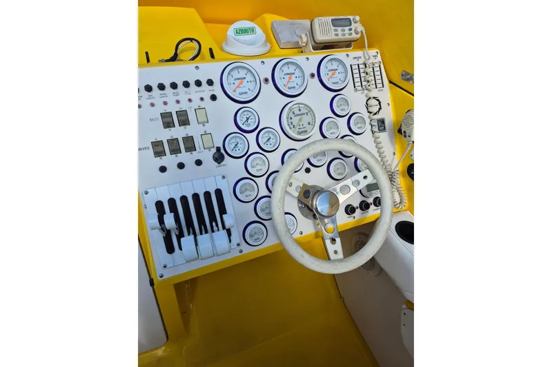 Slide: The Image of Control panel of a 1999 Fountain 47 Lightning boat with gauges and steering wheel. - 6