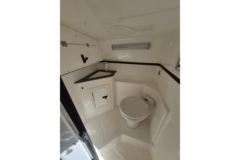 Slide: The Image of 1999 Fountain 47 Lightning boat interior bathroom with toilet and storage compartments. - 13