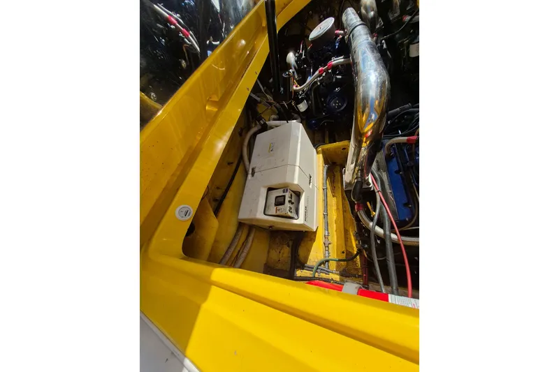 Slide: The Image of Engine compartment of a 1999 Fountain 47 Lightning boat, featuring yellow accents and mechanical components. - 15