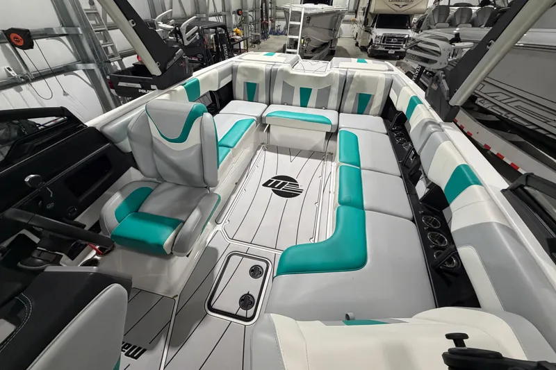 Slide: The Image of 2022 Malibu Wakesetter 23 LSV interior with teal and white seating in a showroom. - 10