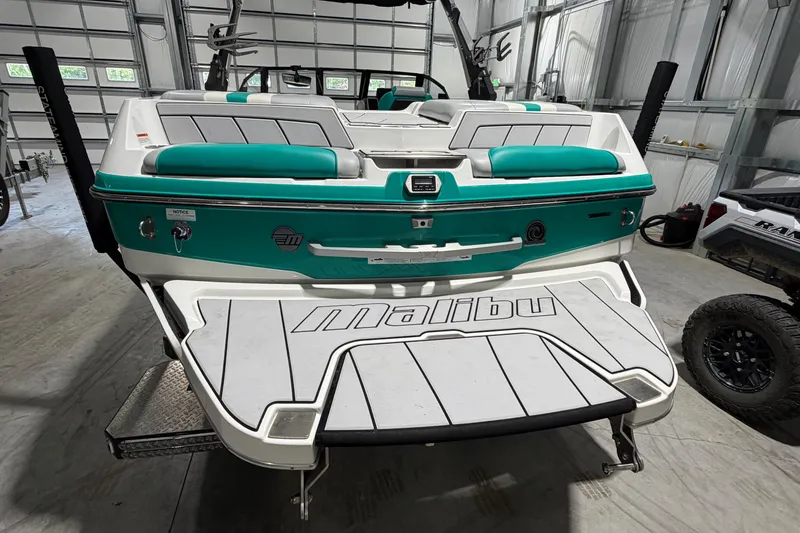 Slide: The Image of 2022 Malibu Wakesetter 23 LSV in a garage, showcasing its sleek design and vibrant teal accents. - 3