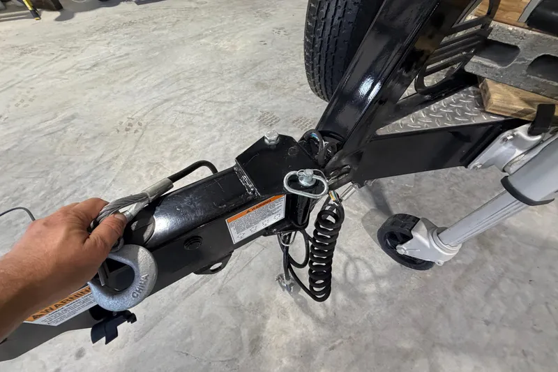 Slide: The Image of Hand securing trailer hitch of 2022 Malibu Wakesetter 23 LSV boat. - 31