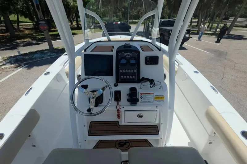 Slide: The Image of 2017 Sea Fox 226 Commander boat dashboard with steering wheel and controls in a parking area. - 17