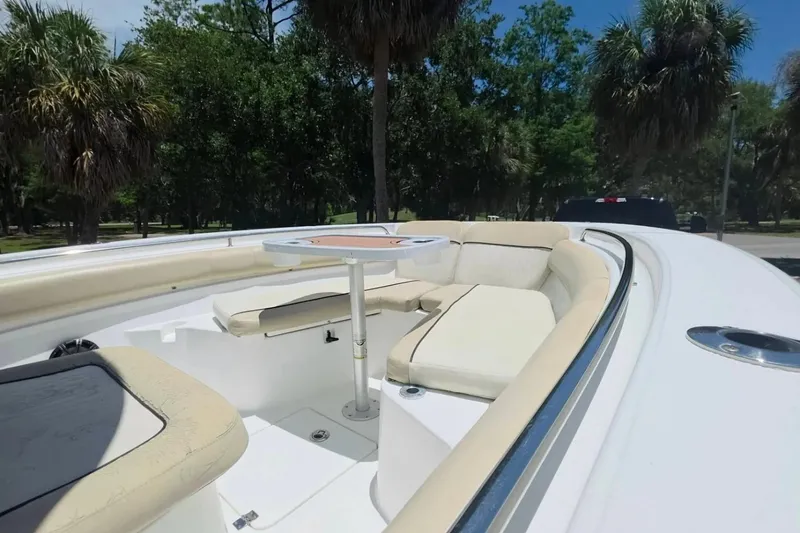Slide: The Image of 2017 Sea Fox 226 Commander boat with cushioned seating and table, surrounded by lush greenery. - 32