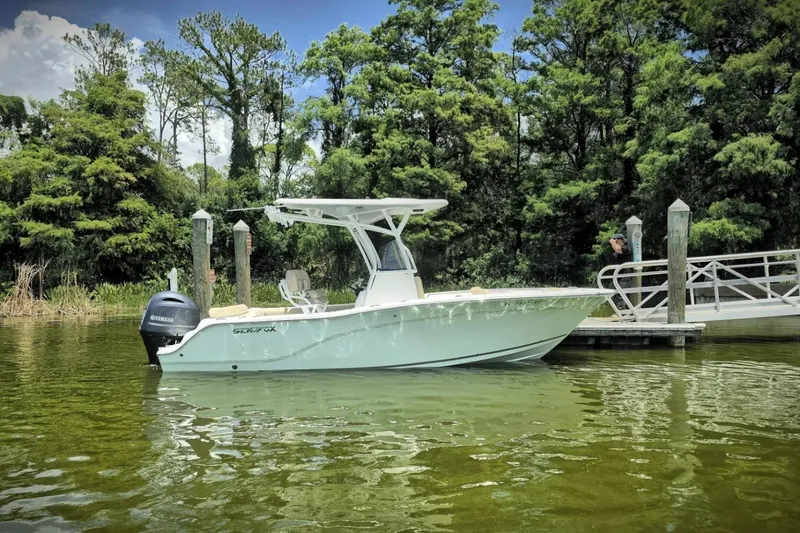 The Image of 2017 Sea Fox 226 Commander boat docked on a serene lake with lush greenery. - 3