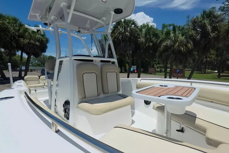 Slide: The Image of 2017 Sea Fox 226 Commander boat interior with seating and table, surrounded by palm trees. - 33