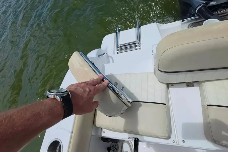 Slide: The Image of Man adjusting seat on 2017 Sea Fox 226 Commander boat near water. - 12