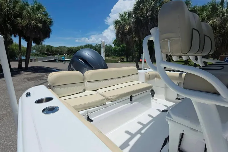 Slide: The Image of 2017 Sea Fox 226 Commander boat interior with beige seating and palm trees in the background. - 8