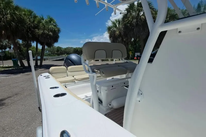Slide: The Image of 2017 Sea Fox 226 Commander boat interior with seating and console, parked near palm trees. - 14