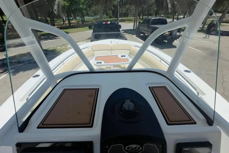 Slide: The Image of 2017 Sea Fox 226 Commander boat interior with windshield and seating area in a parking lot. - 25