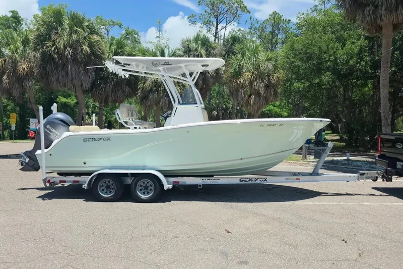 Slide: The Image of 2017 Sea Fox 226 Commander boat on trailer, parked in a sunny, tropical setting. - 1