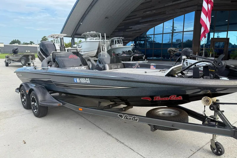 Slide: The Image of 2008 Bass Cat Pantera IV boat on trailer, parked outside a showroom with American flag. - 3